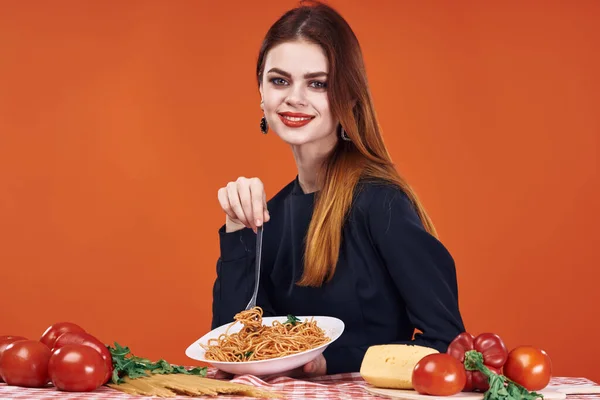 Kobieta siedząca przy stole z jedzeniem spaghetti — Zdjęcie stockowe