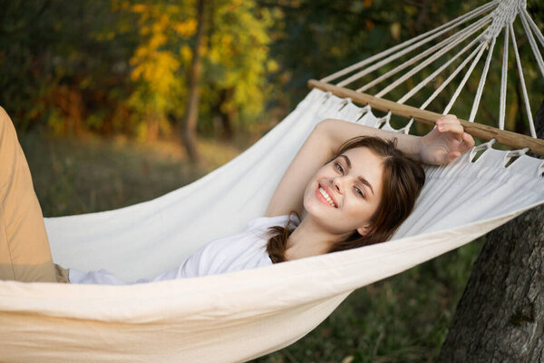 Cheerful woman lies in a hammock rest nature fresh air. High quality photo