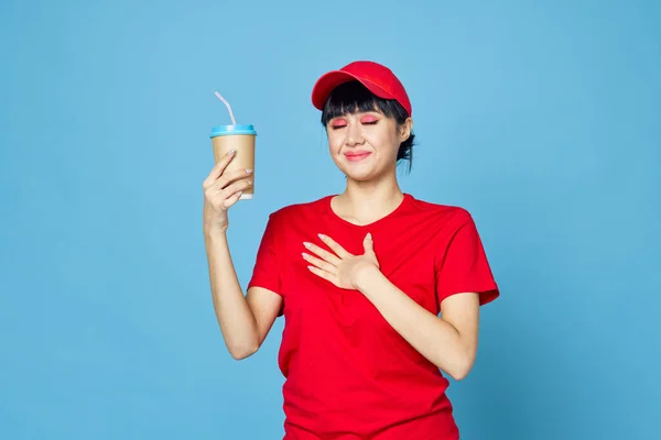 Kobieta w czerwonym mundurze filiżanka kawy niebieski tło zabawy — Zdjęcie stockowe