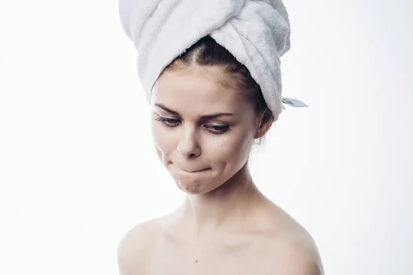 Žena po sprše s ručníkem na hlavě představuje péči o pleť — Stock fotografie