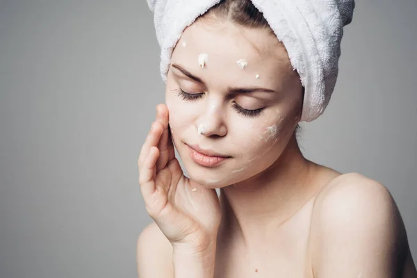 Woman with bare shoulders towel on head face cream skin care — Stock Photo, Image