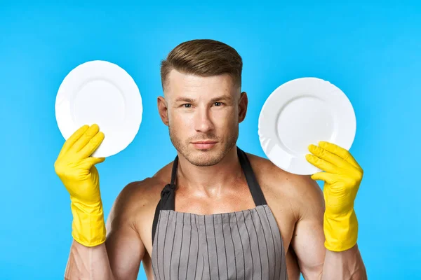 Vrolijke man in schorten afwassen huishoudelijke werk blauwe achtergrond — Stockfoto