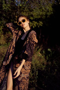 Dışarıda güneş gözlüğü takan bir kadın moda cazibesi sergiliyor.