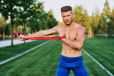 Parkın spor salonunda şişkin vücutlu atletik bir adam.