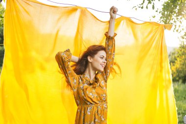 Elleri havada neşeli bir kadın poz veriyor.