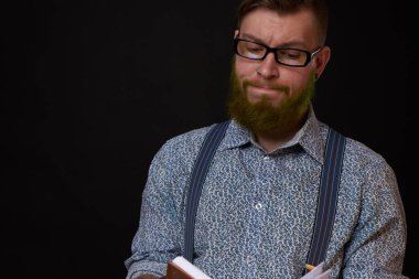 Elinde not defteri olan gözlüklü bir adam profesyonel ofisi eğitiyor.