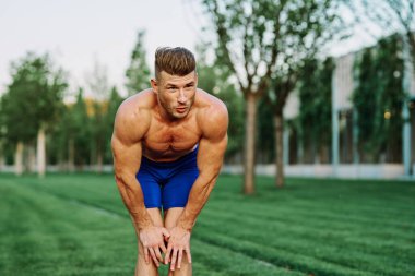 Sportif kaslı adam spor için parktaki spor motivasyonuna gidiyor.