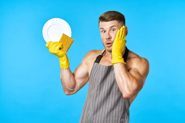 Een man met een opgepompt lichaam met rubberen handschoenen die huiswerk maakt — Stockfoto