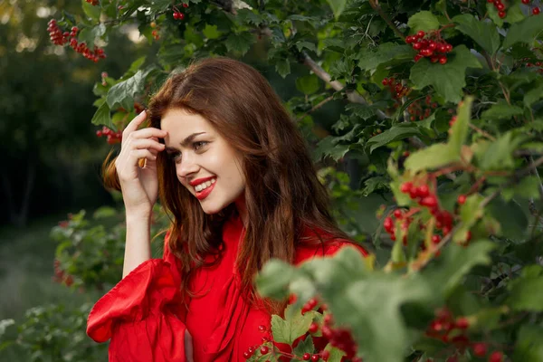 Vacker kvinna i röd klänning glamour poserar natur — Stockfoto