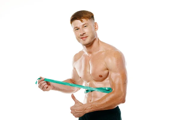 Hombre atlético con cinta métrica entrenamiento muscular — Foto de Stock