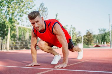 Spor sahası egzersizlerinde kaslı sporcular.