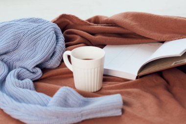 Pencerenin yanında bir battaniye Bir fincan kahve kitabı dinlenme