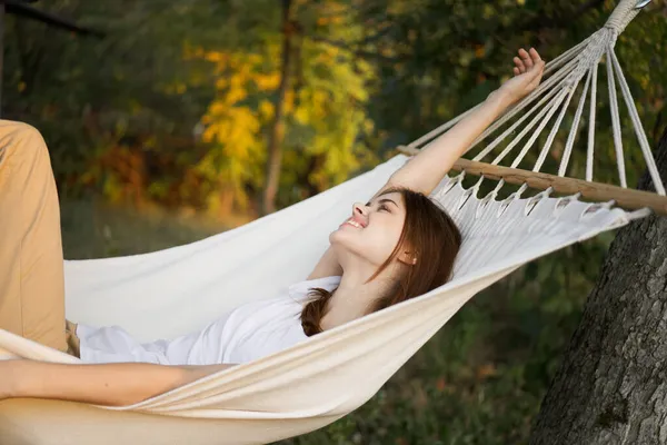 Glad kvinna ligger i en hängmatta vila natur frisk luft — Stockfoto