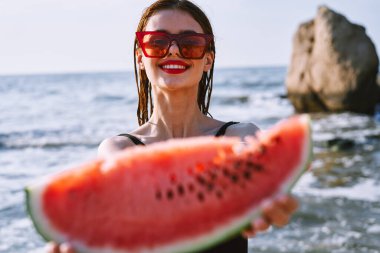 Siyah mayo giymiş neşeli güzel bir kadın karpuz moda seyahati