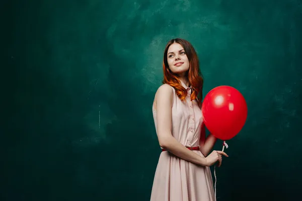 Hübsche Frau im Kleid roten Ballon Geburtstag grünen Hintergrund — Stockfoto