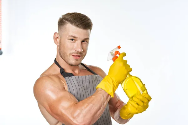 Cheerful man in apron detergent posing muscles — Stock Photo, Image