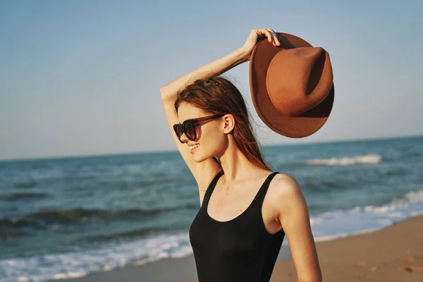 Mulher em um chapéu óculos de sol pelo sol viagem oceano — Fotografia de Stock