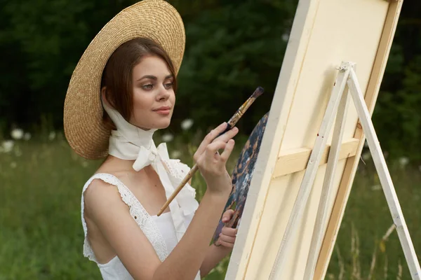 Vrouw in witte jurk buiten kunstenaar tekening ezel — Stockfoto