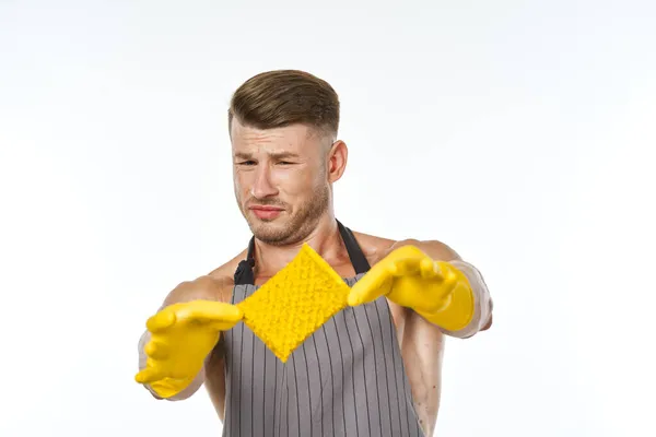 Un uomo in grembiule grigio che indossa guanti di gomma pulizia lavaggio — Foto Stock