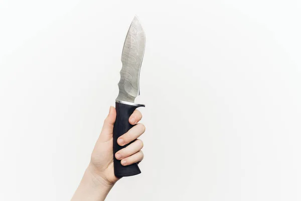Kniv i handen närbild ljus bakgrund eggade vapen — Stockfoto