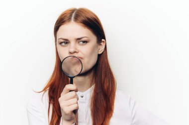 Yüzünde büyüteçle yüzünü buruşturan güzel bir kadın.