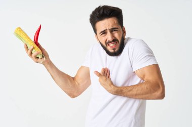 Elinde sebzelerle sakallı bir adam. Sıcak biberli mısır.