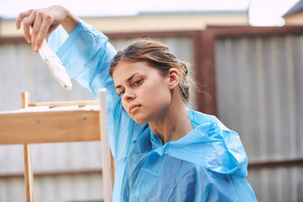 Женщина художник покраска дерева дома ремонт текстуры — стоковое фото