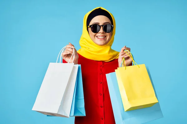 Muslim žena v hidžáb nakupování zábava modré pozadí — Stock fotografie