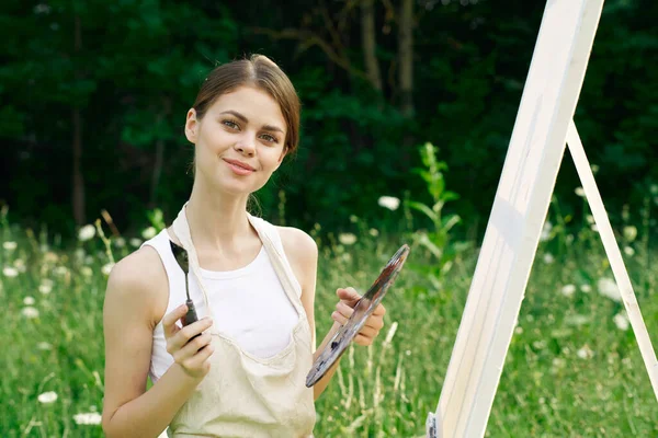 Wesoła kobieta maluje obraz paleta krajobraz przyrody — Zdjęcie stockowe