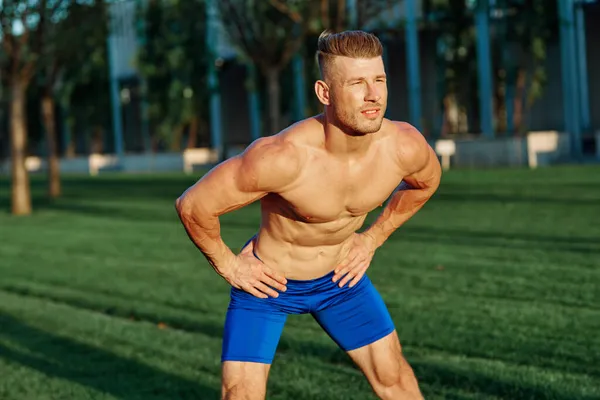 Homem com corpo muscular exercitando no parque de verão — Fotografia de Stock