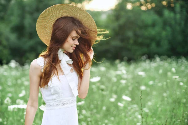 하얀 드레스를 입고 자연의 꽃을 타고 걷는 명랑 한 여인 — 스톡 사진