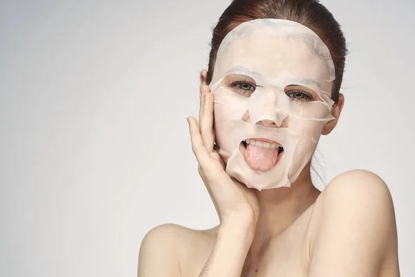 Emocionální žena kosmetické obličeje maska close-up světlo pozadí — Stock fotografie