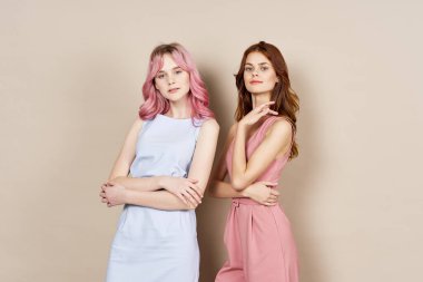 İki kadın yazın moda kıyafetler giyip aksesuar takıyor.