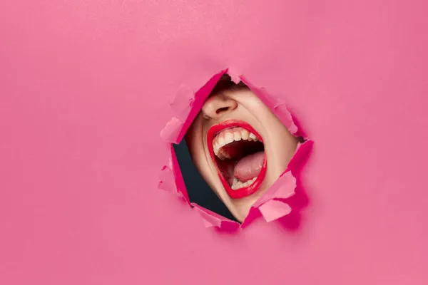 Vidám nő poszter lyuk rózsaszín háttér és piros ajkak — Stock Fotó