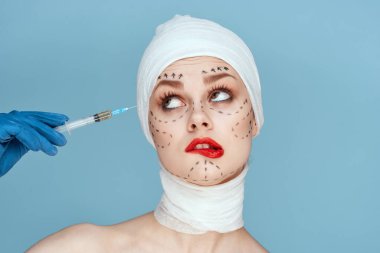 Mavi eldivenli kadın kırmızı dudaklı ameliyat yüzü gençleştirme mavi arka plan