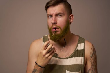 Kollarında vahşi erkek dövmeleri var. Kesilmiş bir yaşam biçimi gibi duruyor.