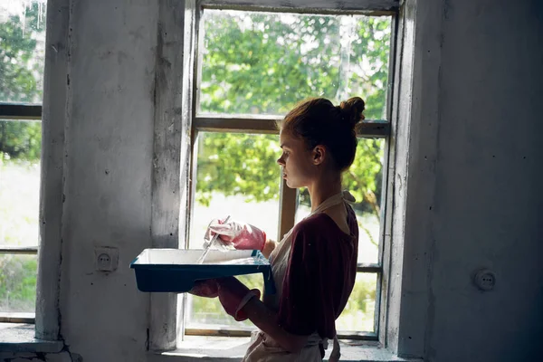 Femme peint les fenêtres dans la maison intérieur salle rénovation — Photo