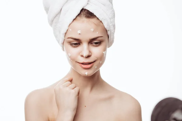 Mulher alegre com uma toalha branca em sua cabeça creme de rosto cuidados com a pele — Fotografia de Stock