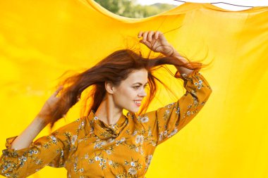 Sarı elbiseli kadın, saç stili eğlencesi.