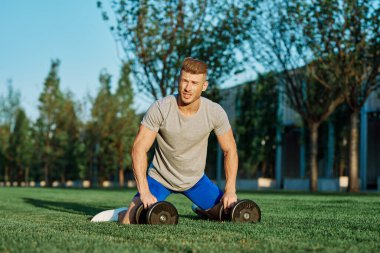 Spor salonunda dambılı olan atletik bir adam.