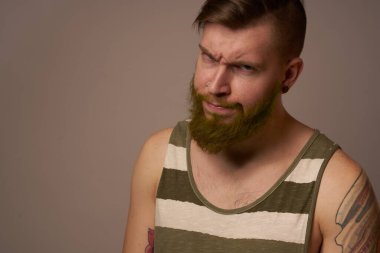 Kollarında dövmeleri olan yakışıklı bir adam. Saç stili duyguları var.