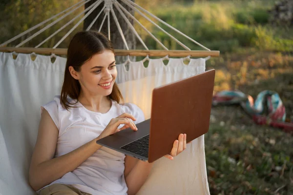Kobieta z laptopem i leży w hamaku wakacje natura freelance — Zdjęcie stockowe