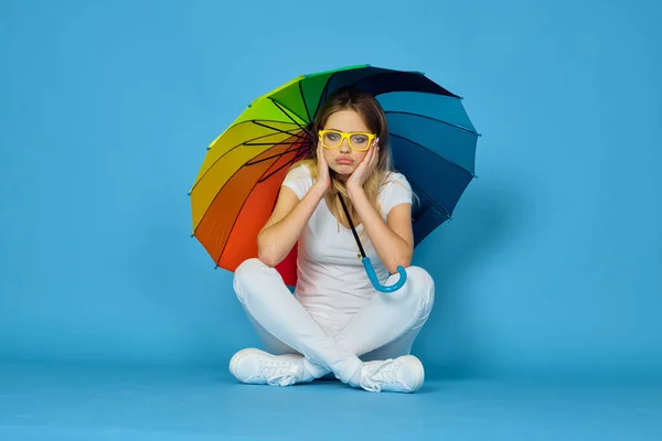 Donna alla moda con ombrello arcobaleno colori posa sfondo blu — Foto Stock