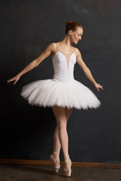 Beyaz etekli bir kadın balerin. Performansları siyah arka plan. — Stok fotoğraf