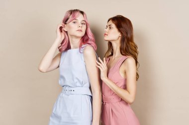 İki kadın yazın moda kıyafetler giyip aksesuar takıyor.