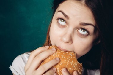 Hamburger yiyen bir kadın.