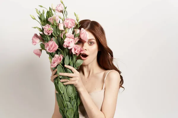 Femme gaie en robe posant fleurs maquillage fond isolé — Photo