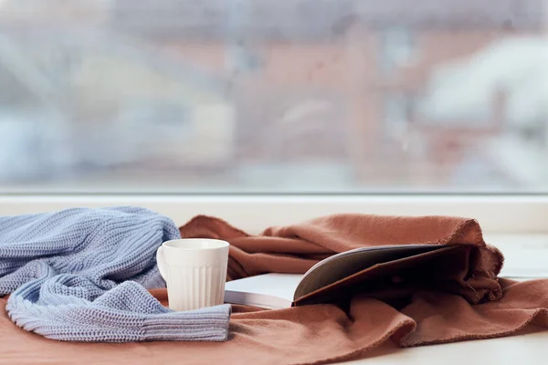 Одеяло у окна чашка кофе книги Комфортный отдых — стоковое фото
