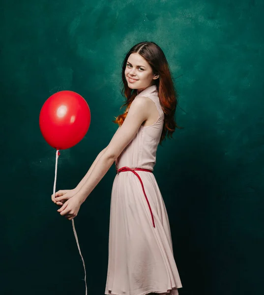 Hübsche Frau im Kleid roten Ballon Urlaub grünen Hintergrund — Stockfoto
