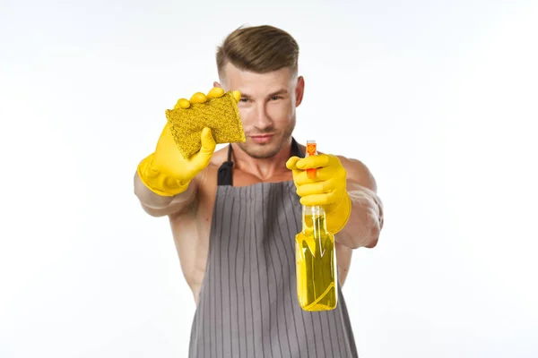 Pumped up man in an apron with rubber gloves detergents — Stock Photo, Image